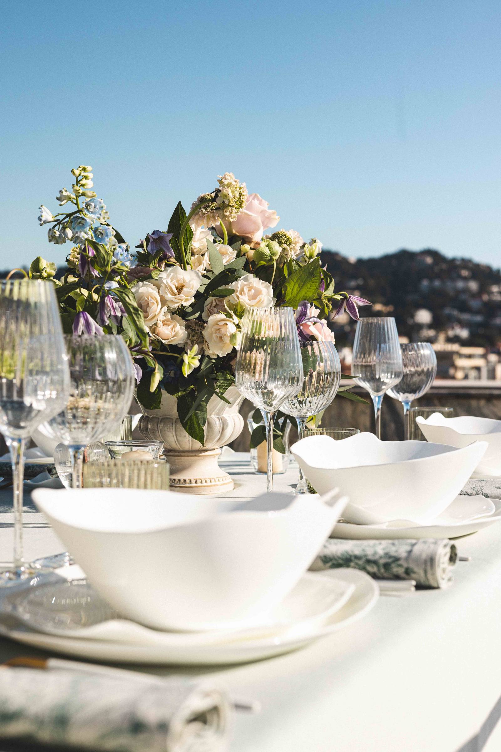 Un centre de table fleuri entouré de verres taillés