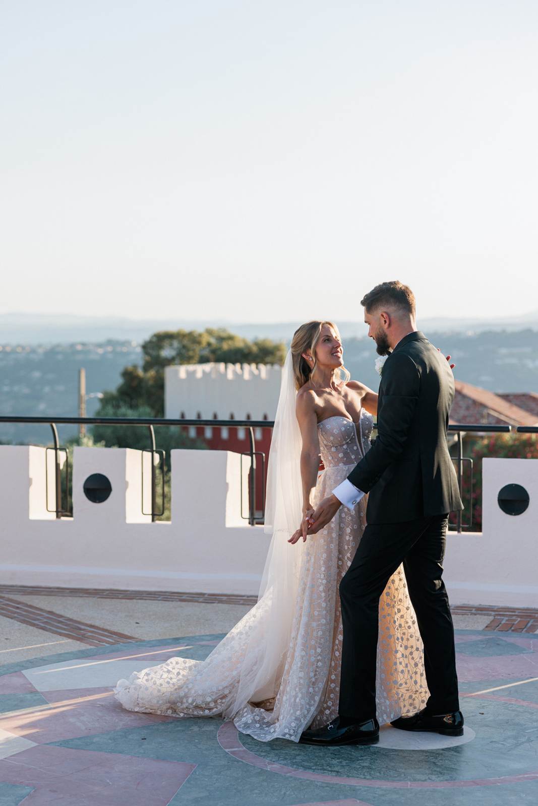 The newlyweds dancing on a terrace facing the hills