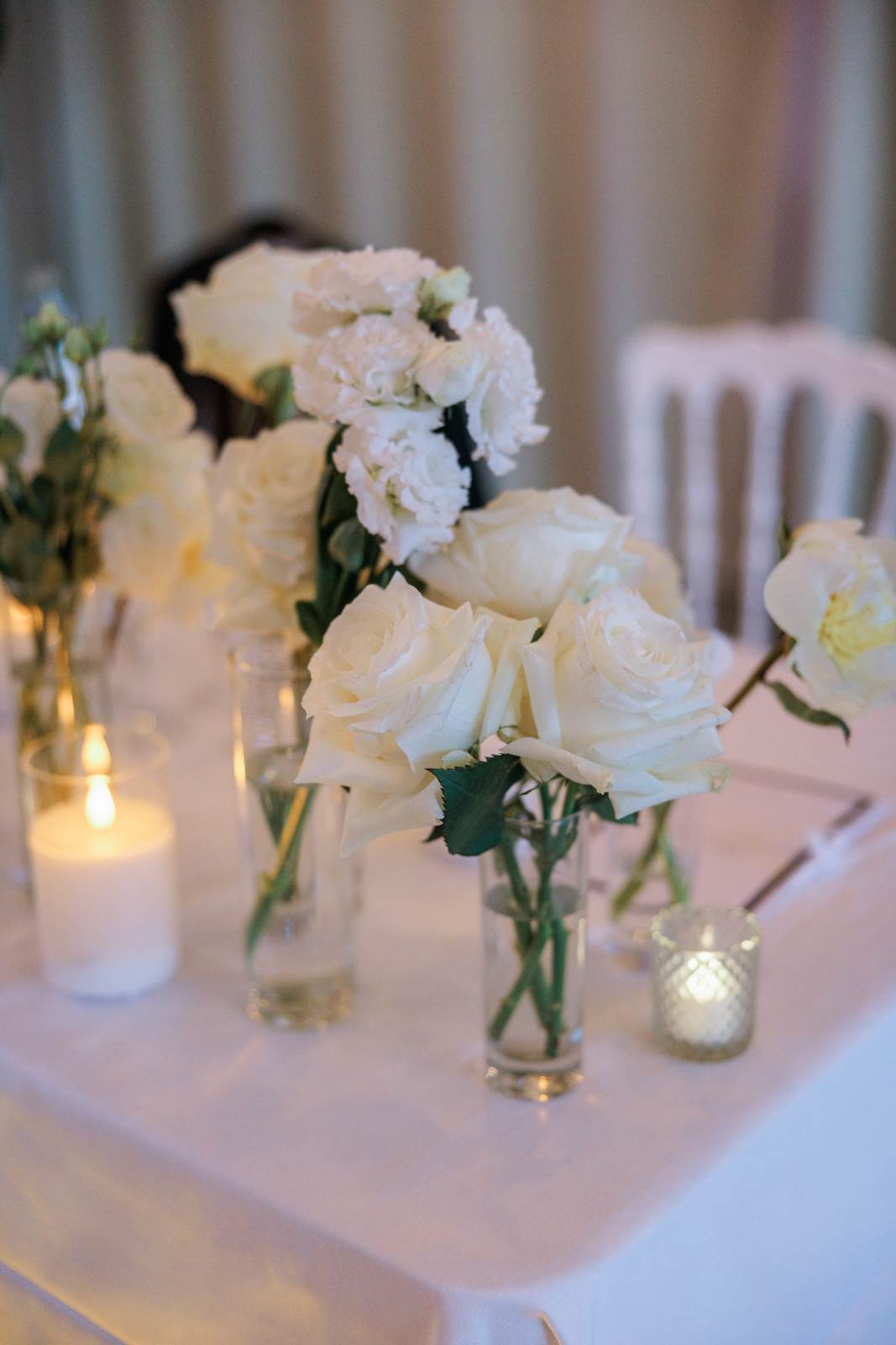 White roses and candles on the newlyweds’ table