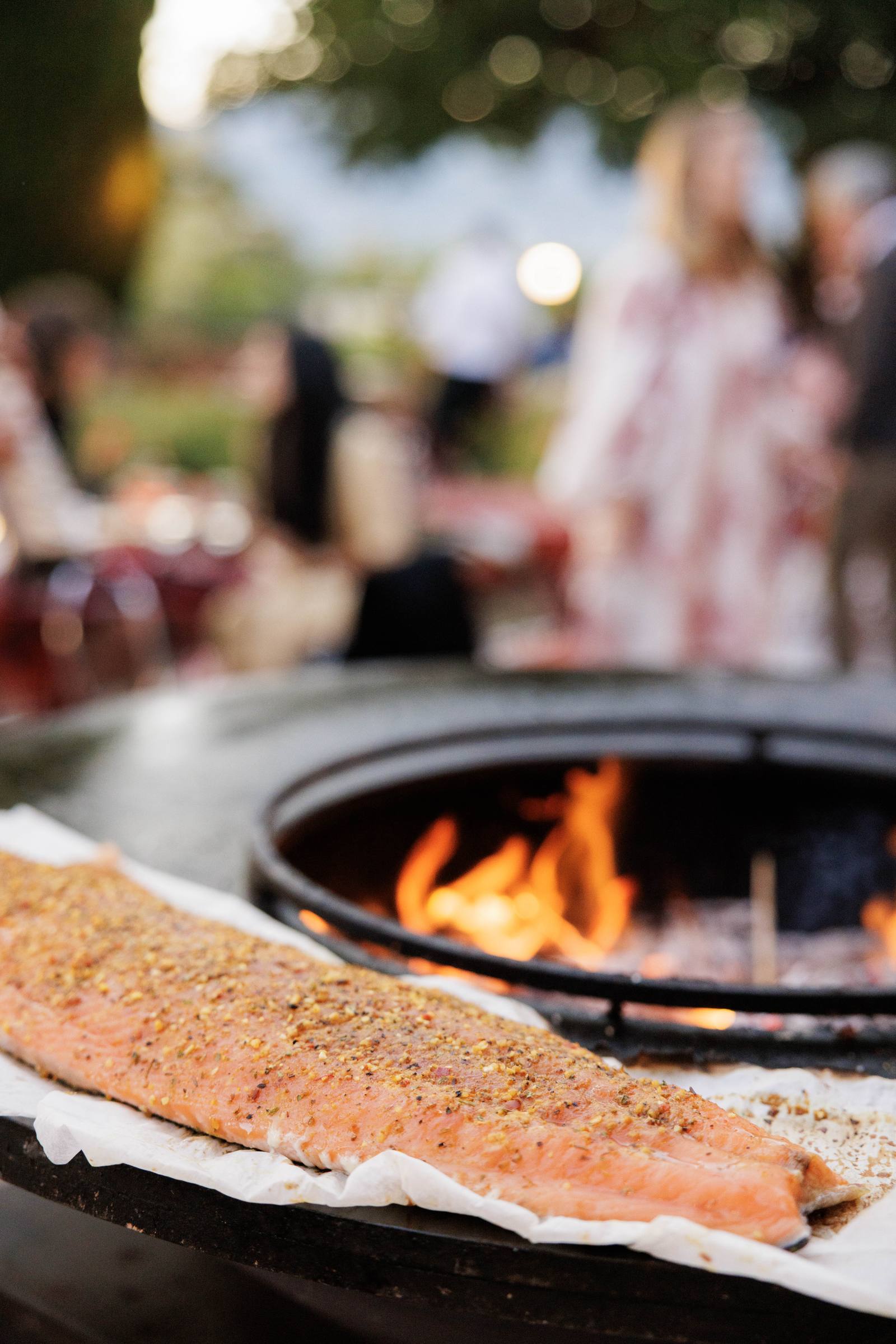 Un filet de saumon sur le brasero, devant les invités