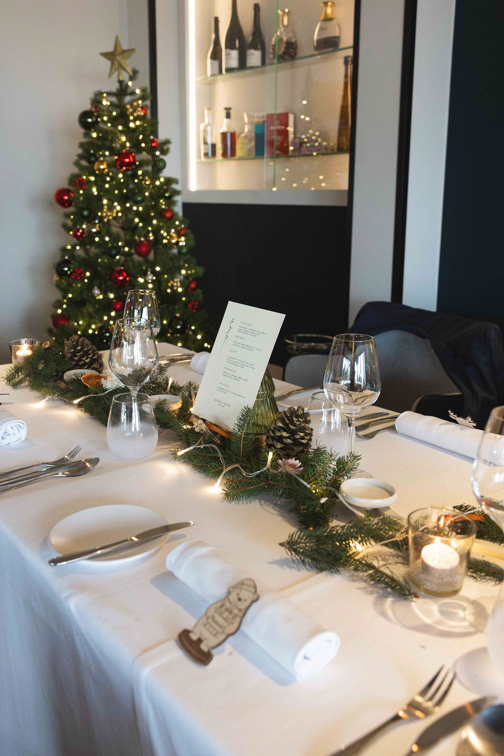 The table laid for dinner, in front of a lit Christmas tree