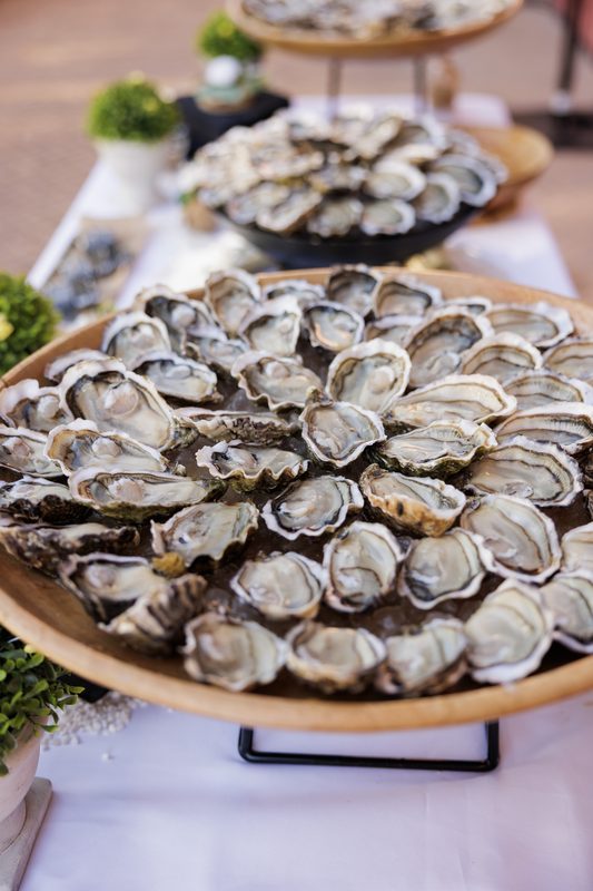 Two large trays of shucked oysters on a buffet