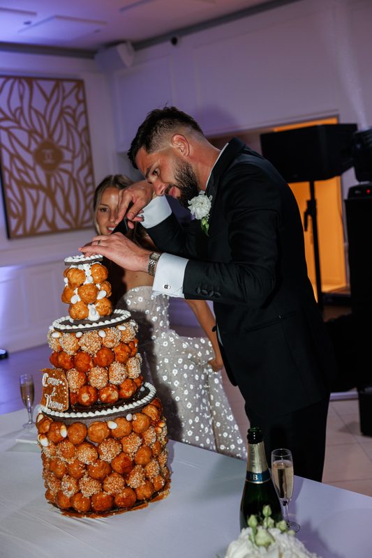 Un couple découpe une pièce montée de choux caramélisés